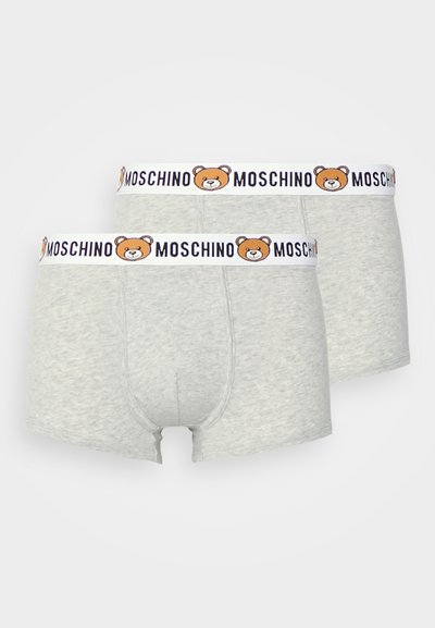 Pelēki kokvilnas bokseri ar baltu jostu, uz kuras attēlots lāča dizains un "Moschino" teksts zilā krāsā, piedāvā ciešu piegulšanu un gludu tekstūru.