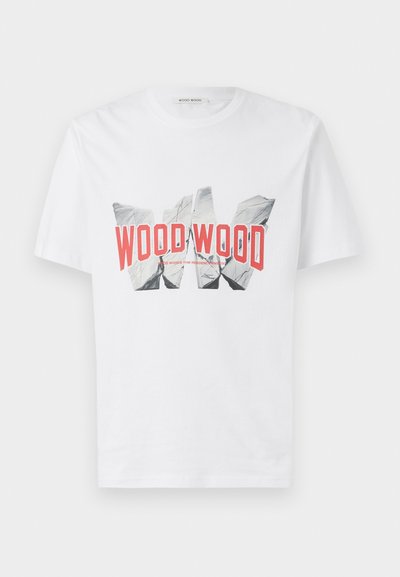 Balta medvilninė marškinėlių viršutinė dalis, puošta drąsiu raudonu ir juodu grafiniu atspaudu su tekstu "WOOD WOOD", nusistovėjusi švarioje fone.