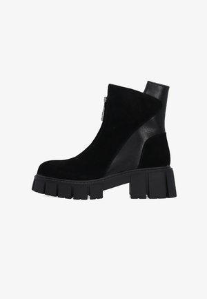 Black ankle boot with a combination of suede and leather. Features a side zip closure and a chunky, textured platform sole.