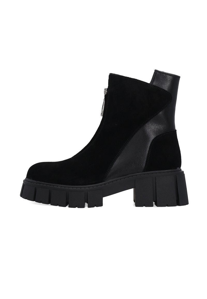 Zwarte enkelboot van een combinatie van suede en leer. Beschikt over een zijrits en een chunky, gestructureerde platformzool.