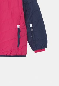 Pohodlná bunda s vycpávkami v růžovo-námořnické barevné kombinaci, která má horizontální prošívání, kapsy na zip a elastické manžety pro těsné padnutí.