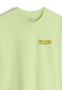 Camiseta de algodón verde claro con cuello redondo, con un logo amarillo "VANS" en el pecho izquierdo. Diseño de ajuste holgado.