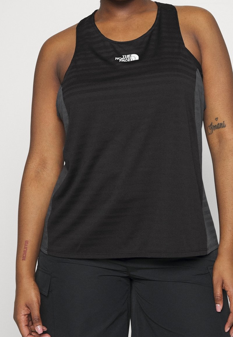 Czarny sportowy top bez rękawów z teksturowanym wzorem w paski, z dekoltem w kształcie łódki i logo. Boczne panele w jaśniejszym odcieniu.