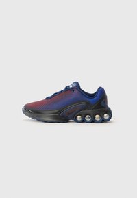 Nike atletska cipela s gornjim dijelom od mrežice u gradijentu crvene i plave boje, crnim srednjim dijelom, i karakterističnim kružnim elementima za ublažavanje.