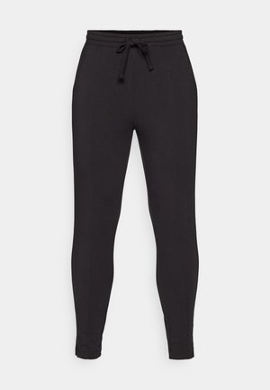 Pantalones de chándal negros hechos de una tela suave, con una cinturilla elástica y cordón, piernas ajustadas y detalles en las costuras laterales.