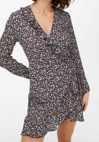 Sukienka w kwiatowy wzór w ciemnym granacie, posiada falbaniasty dekolt w kształcie V oraz długie rękawy, z rozkloszowanym dołem i lekką teksturą materiału.