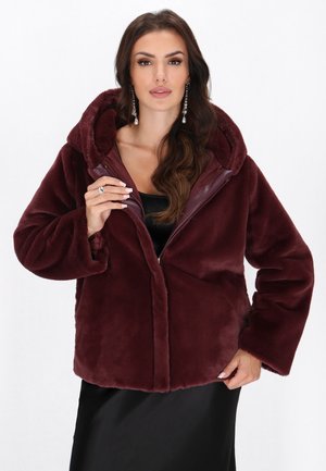 Bordeaux nepvachtenjas met een capuchon, ritsluiting en zijzakken. Zachte textuur en een oversized pasvorm met brede mouwen.