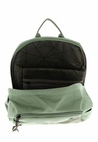 Mochila de tela verde con forma redondeada, que cuenta con un compartimento principal con cremallera, bolsillos organizadores en el interior y una asa tejida.