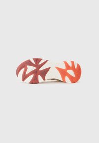 Shoe sole features a red and orange gradient design with a textured white base, showcasing a star-shaped pattern for grip.