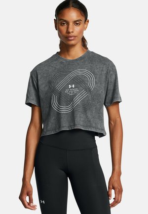 Hallitatud hall lühike t-särk, millel on valge graafiline kujundus ja "Under Armour" logo. Modell kannab musti kõrge vöökohaga retuuse.