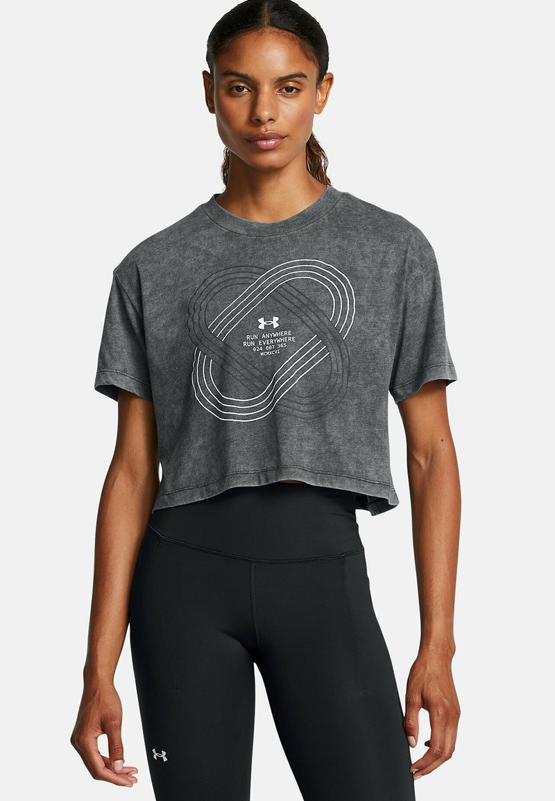 Grijze cropped t-shirt met een witte grafische print en het 'Under Armour' logo. Het model draagt zwarte high-waisted leggings.