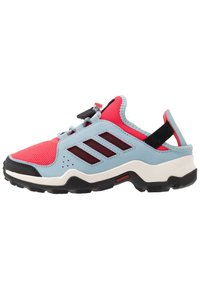 Moniväriset urheilukengät, joissa on hengittävä punainen verkko-osa, pehmeät siniset päällysteet, mustat yksityiskohdat ja teksturoitu musta pohja.