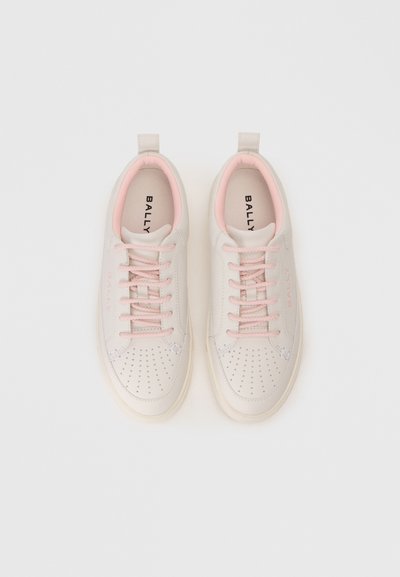 White leather sneakers with pink accents, perforated toe area, and matching laces. Features a pull tab and brand name inside.