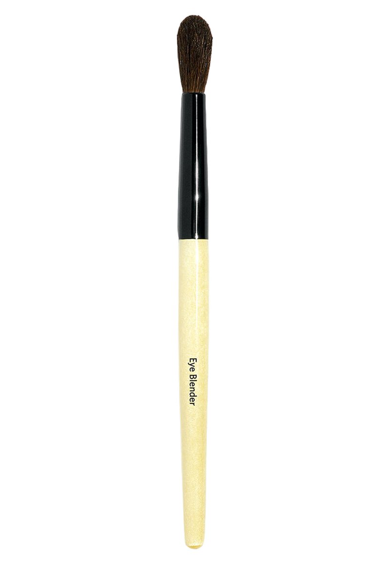 Pennello per ombretto con testa a setole scura, appuntita e morbida, ghiera nera e manico lungo, sottile e testurizzato di colore crema. Testo stampato sul manico.