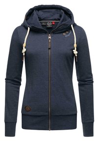 Granatowa bluza z kapturem na zamek, charakteryzująca się teksturowanym materiałem, sznurkami w stylu linowym oraz brązową naszywką z logo w pobliżu dolnej krawędzi.