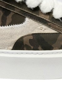 Sneaker con motivo camouflage che presenta un mix di tessuto testurizzato e pelle liscia, con lacci bianchi e una suola in gomma bianca.
