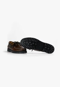 Zapatos náuticos de cuero marrón con costuras y cordones blancos. Suela de goma negra con un patrón de grosor para mayor tracción. Diseño clásico.