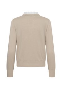 Pull beige à manches longues avec poignets et ourlet côtelés, avec un col blanc à volants au niveau de l'encolure.