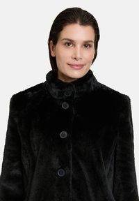 Black faux fur coat with a high collar, featuring four black buttons down the front. Soft texture and streamlined design.