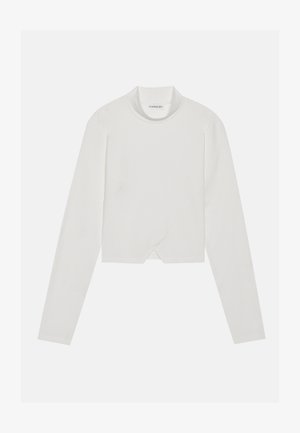 Maglietta bianca a maniche lunghe con collo alto, caratterizzata da un design con cuciture diagonali e orlo corto. Tessuto morbido con una texture liscia.