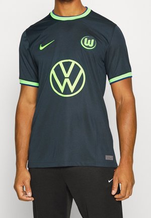 Maillot de football noir et vert avec les logos Volkswagen et du club de Wolfsburg, porté par une personne à la peau foncée et un pantalon noir.