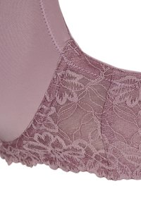 Sostenitore con una combinazione di morbido tessuto lilla e dettagli in pizzo floreale. Il design include spalline regolabili e un bordo decorativo a merletto.