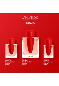 Tres botellas de Shiseido Ginza Eau de Parfum Intense en tamaños de 30ml, 50ml y 90ml sobre un fondo rojo con los nombres de la marca y el producto.