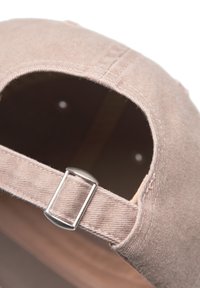 Cap gemaakt van zacht beige stof, met een gebogen rand, een verstelbare riem met een metalen gesp, en zichtbare binnenvoering.