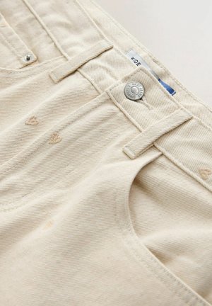Beige cotton trousers with a textured finish, featuring a metal button closure, stitched belt loops, and subtle heart embroidery.