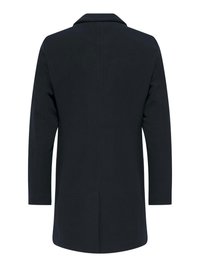 Manteau bleu marine avec une texture lisse, à manches longues et col. Doté d'une coupe droite et d'un fente au dos pour faciliter les mouvements.