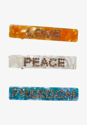 Trois pinces à cheveux : orange avec "AMOUR" en strass, blanche avec "PAIX" et aqua avec "LIBERTÉ", toutes présentant une finition marbrée.