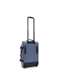 Rolling suitcase in light blue fabric with black accents, side handles, two wheels, and a retractable handle for easy transportation.