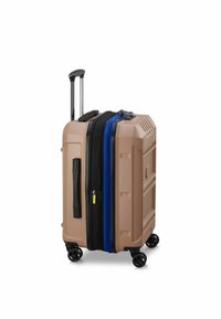 Valigia rigida di colore beige con cerniere nere e blu. Dispone di un manico estraibile e quattro ruote per la mobilità. Dettagli sulla superficie testurizzati.