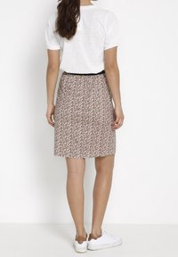 Falda de estampado floral con tejido ligero, diseño a la altura de la rodilla, cintura elástica y corte relajado, combinada con una camiseta casual de manga corta.