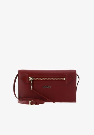 Sac bandoulière DKNY en cuir rouge avec poche zippée dorée et sangle réglable, forme rectangulaire avec finition texturée.