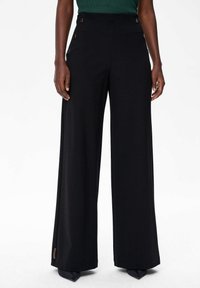 Zwarte wijde broek gemaakt van een gladde stof, met een hoge taille en metalen knoopdetails aan de zijkant, en een op maat gemaakte silhout. 