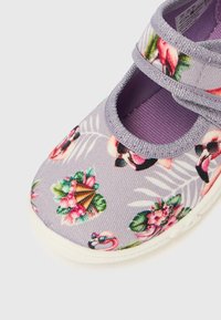 Boty s květinovým vzorem, s lila textilním svrškem, elastickými pásky a bílou gumovou podrážkou. Výrazné jsou tropické motivy.
