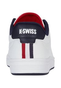 Weiße K-Swiss Sneaker mit einem roten und navy gestreiften Akzent an der Ferse. Ausgestattet mit einem strukturierten Lederoberteil und gepolstertem Kragen. Logo auf der Rückseite.