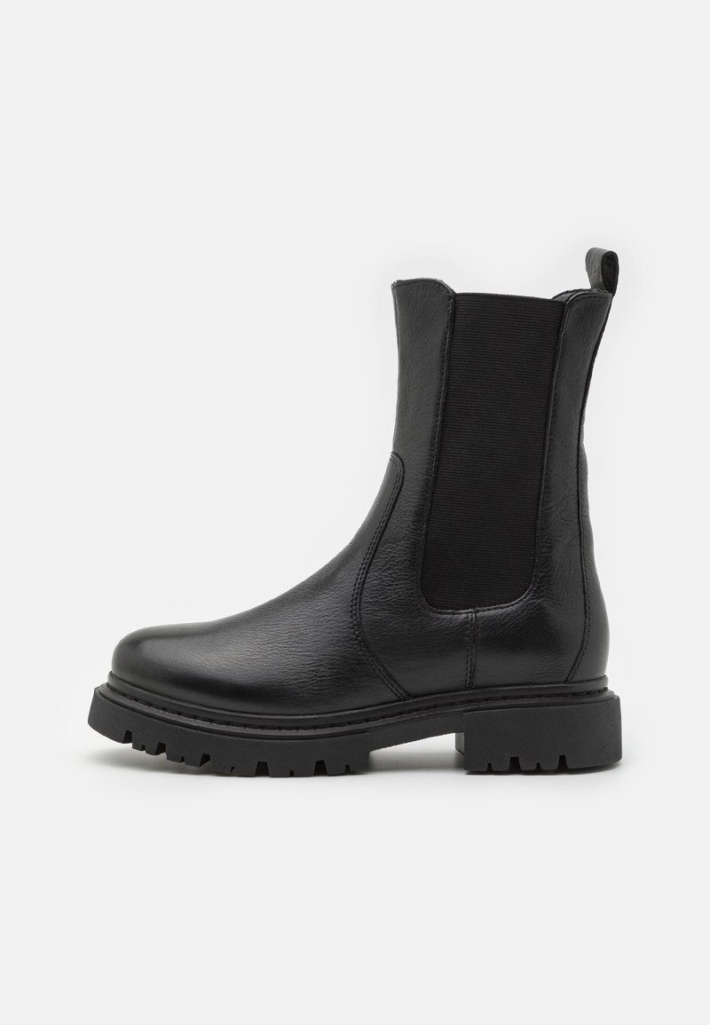 Botas de tornozelo em couro preto com painéis laterais elásticos, bico arredondado e sola robusta com ranhuras de tração pronunciadas.