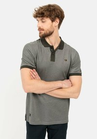Graues Polo-Shirt mit dunkelgrünem Kragen und Ärmeln, kurzen Ärmeln, normaler Passform, mit einem gelben Logo auf der linken Brust.