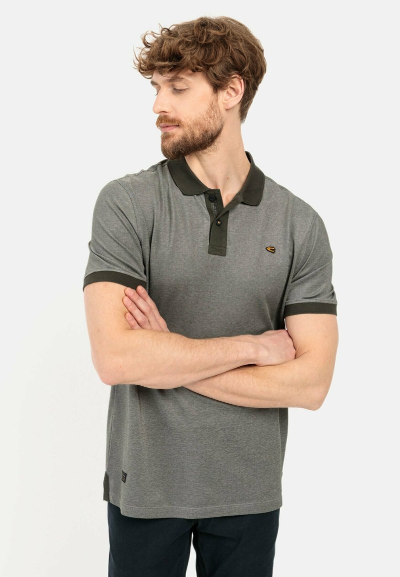 Graues Polo-Shirt mit dunkelgrünem Kragen und Ärmeln, kurzen Ärmeln, normaler Passform, mit einem gelben Logo auf der linken Brust.