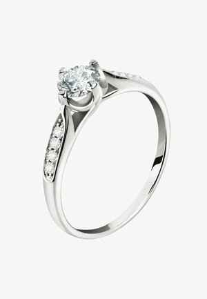 Runder Diamantring aus Weißgold. Ausgestattet mit einem großen zentralen runden Diamanten und kleineren Seitendiamanten am Band. Glatte, polierte Oberfläche.