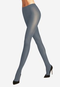 Collant grigi opachi con una superficie liscia e una leggera lucentezza, abbinati a scarpe con tacco nere. I collant presentano un design con vita alta.