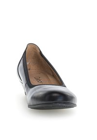 Bailarinas de cuero negro con punta redondeada, ribete elástico y suela de goma texturizada. El interior cuenta con una plantilla acolchada para mayor comodidad.