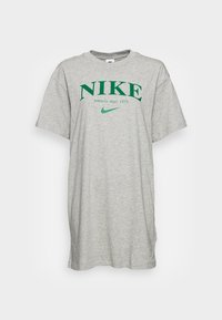 Camiseta de algodón gris con mangas cortas y cuello redondo, que muestra "NIKE Athletic dept. 1972" en letras verdes y un logotipo.