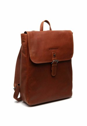 Sac à dos en cuir marron avec rabat et fermeture à boucle, bretelles réglables et poignée de transport supérieure sur fond blanc.