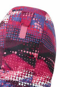 Kolorowa tkanina z wzorem w odcieniach różu, fioletu i czerni z geometrycznymi kształtami. Zawiera różową pętlę do trzymania.