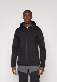Giacca ibrida nera con zip frontale, torso imbottito e maniche in fleece. Presenta un cappuccio, tasche con zip e un design aderente.