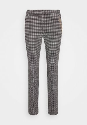 Slim-fit ankle-length pants with black and white houndstooth pattern and side zip pocket detailing.
