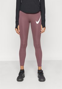 Μπορντό αθλητικό κολάν με εφαρμοστή σχεδίαση, με εμφανές λευκό λογότυπο της Nike, κατασκευασμένο από λείο, ελαστικό υλικό.